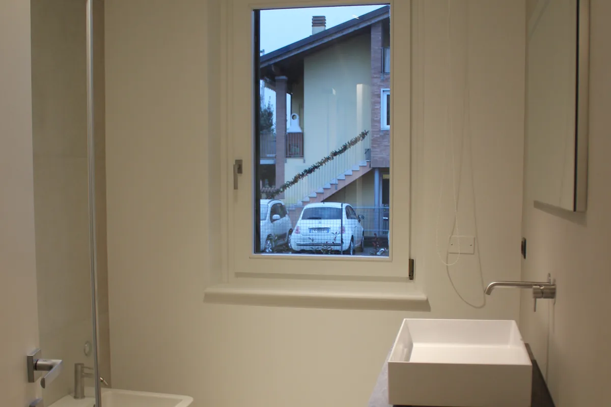 Bagno ristrutturato con rivestimenti in ceramica e box doccia in vetro — intervento a Sona